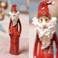 Ceramiczna figurka stojącego mikołaja z rękoma w kieszeniach szkliwionego w kolorze czerwonym z długą białą brodą i w okularach.jpg