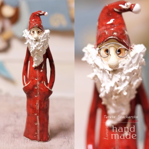 Ceramiczna figurka stojącego mikołaja z rękoma w kieszeniach szkliwionego w kolorze czerwonym z długą białą brodą i w okularach.jpg