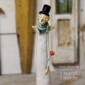 Ceramiczny anioł stojący trzymający w ręku czerwoną różę.jpg