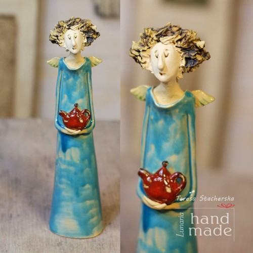 Ceramiczna figurka anioła w turkusowej sukni trzymającego czerwony imbryk.jpg